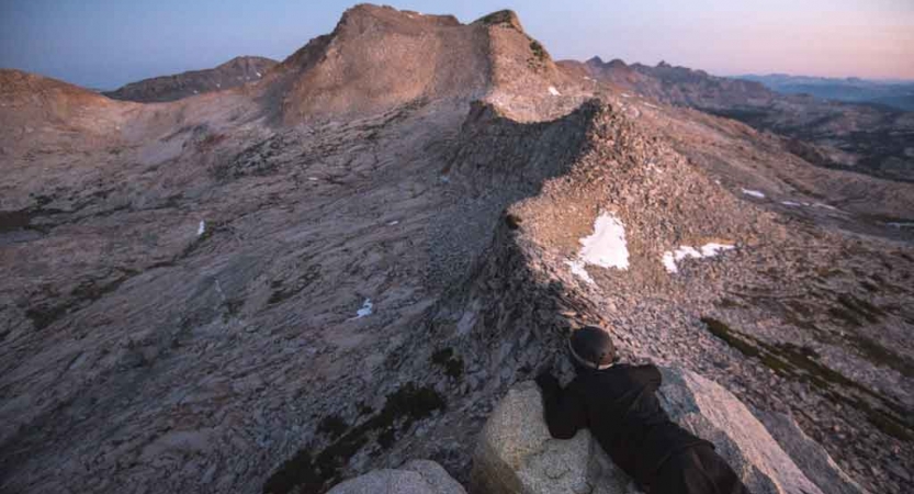 A mountainous ridge appears under pink and purple skies in California's Sierra Nevada Range. 